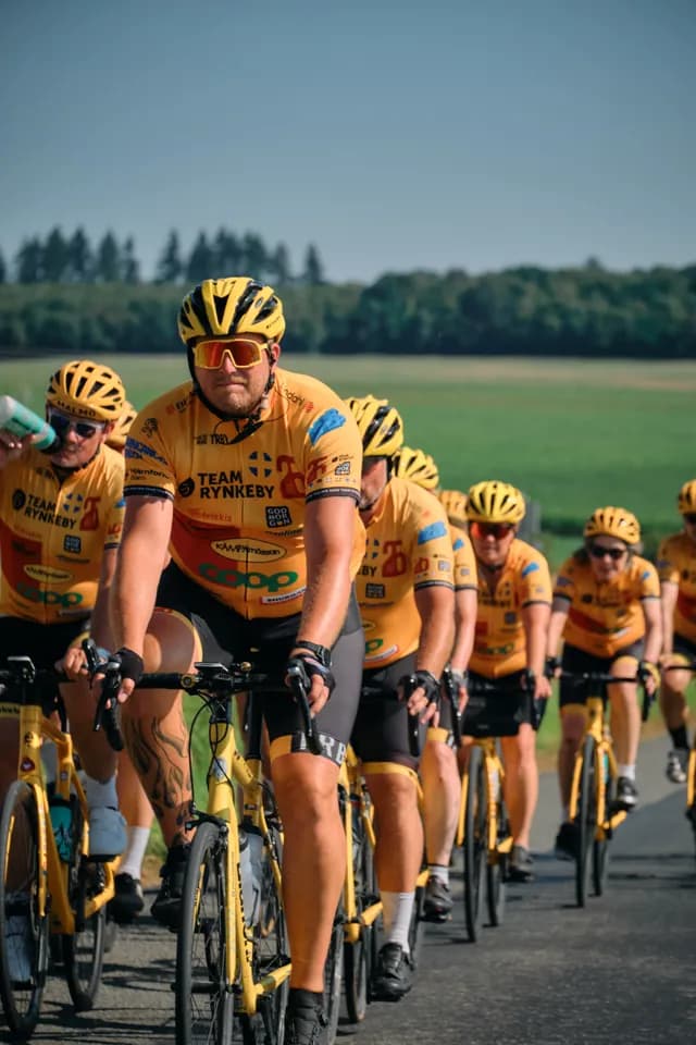 En Team Rynkeby-rytter forrest i feltet, med trøjen fuld af sponsorlogoer